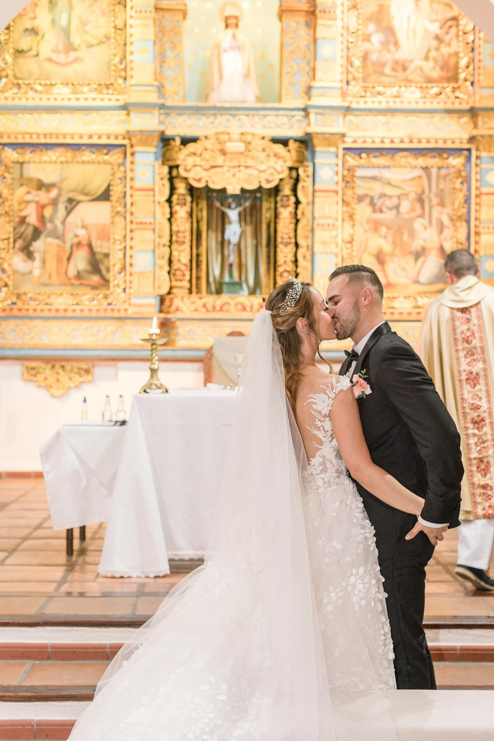 Bride and groom kissing at altar during historic church ceremony in Antioquia