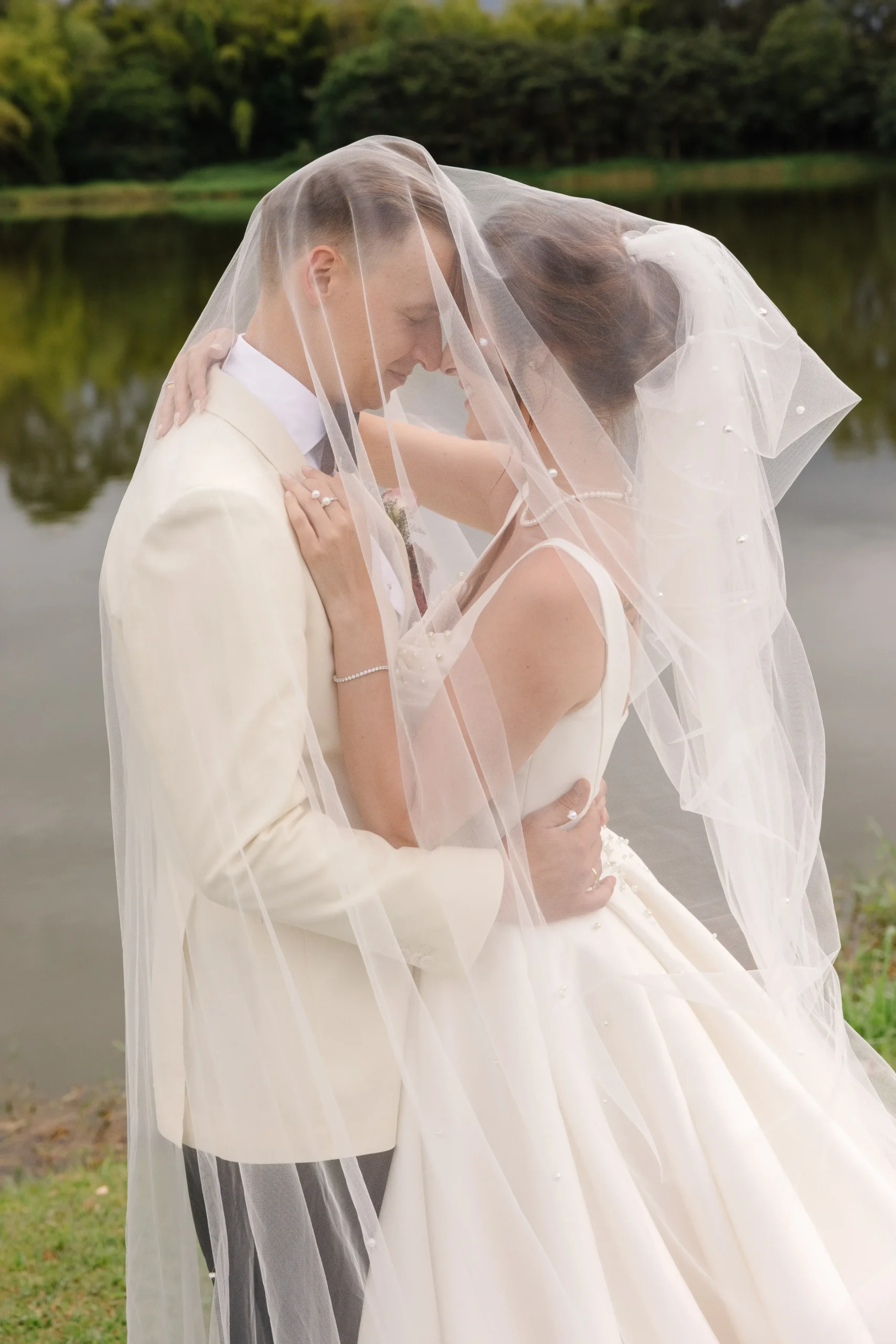 Romantic bride and groom embrace beneath a cathedral veil