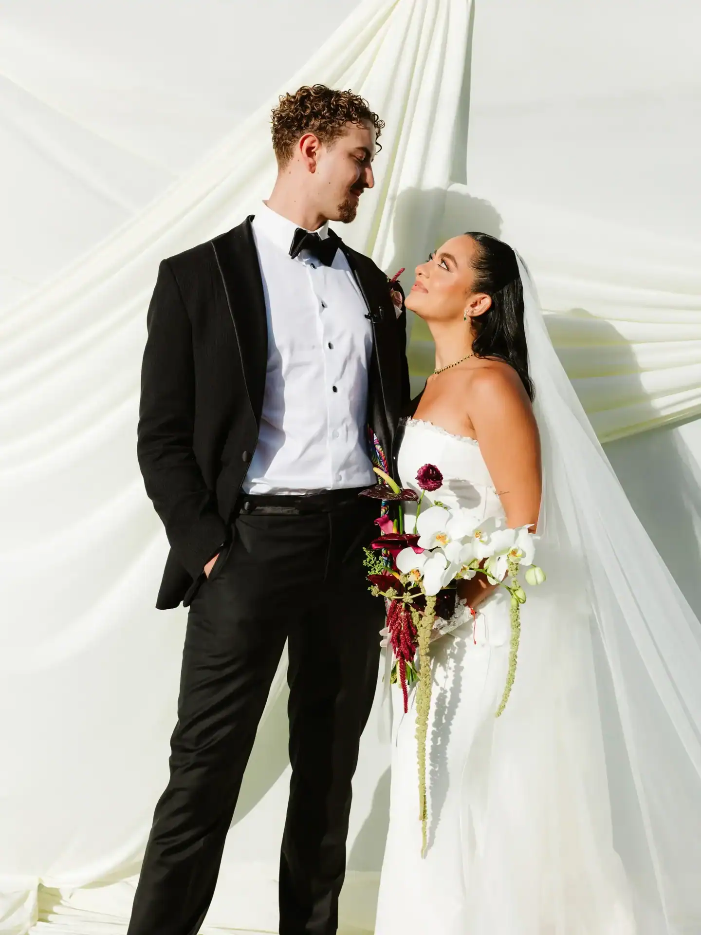 Bride and groom smiling together outdoors in fine art wedding attire in Llanogrande